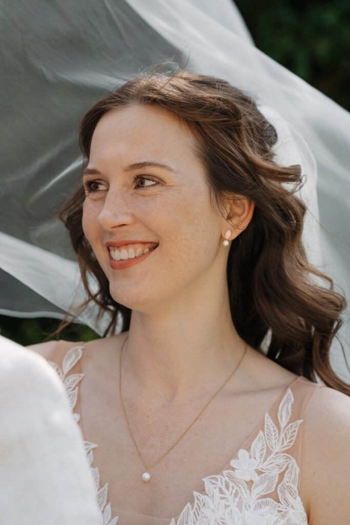 Braut lächelt im natürlichen Licht während der Hochzeit