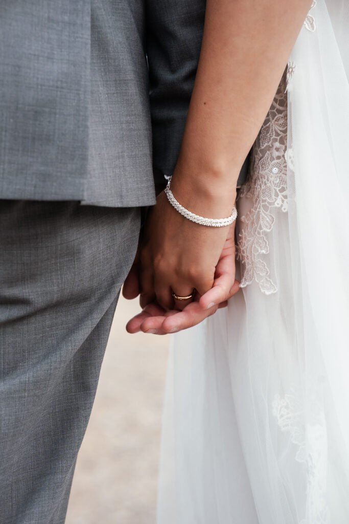 Brautpaar hält während der Hochzeit Händchen
