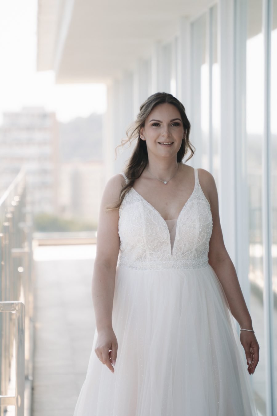 Braut im weißen Hochzeitskleid in heller Atmosphäre