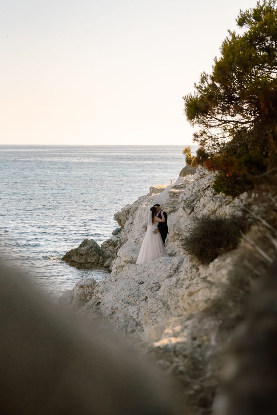 Brautpaar auf einer Klippe am Meer bei einem romantischen Hochzeitsshooting auf Mallorca